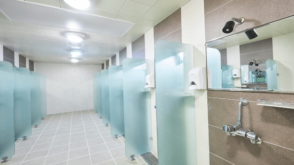shower heads, mirror, and glass separators in public shower room facility