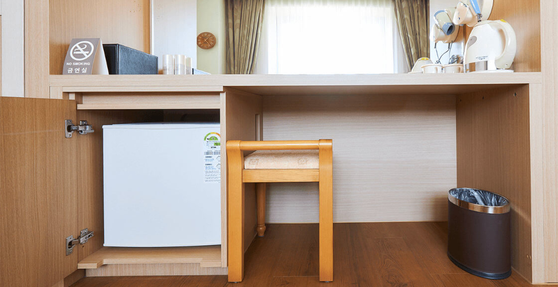 mini fridge, a chair, hair dryer and trash bin