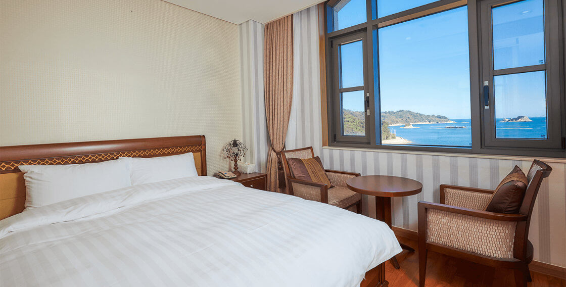 queen size bed and beach View of deluxe room